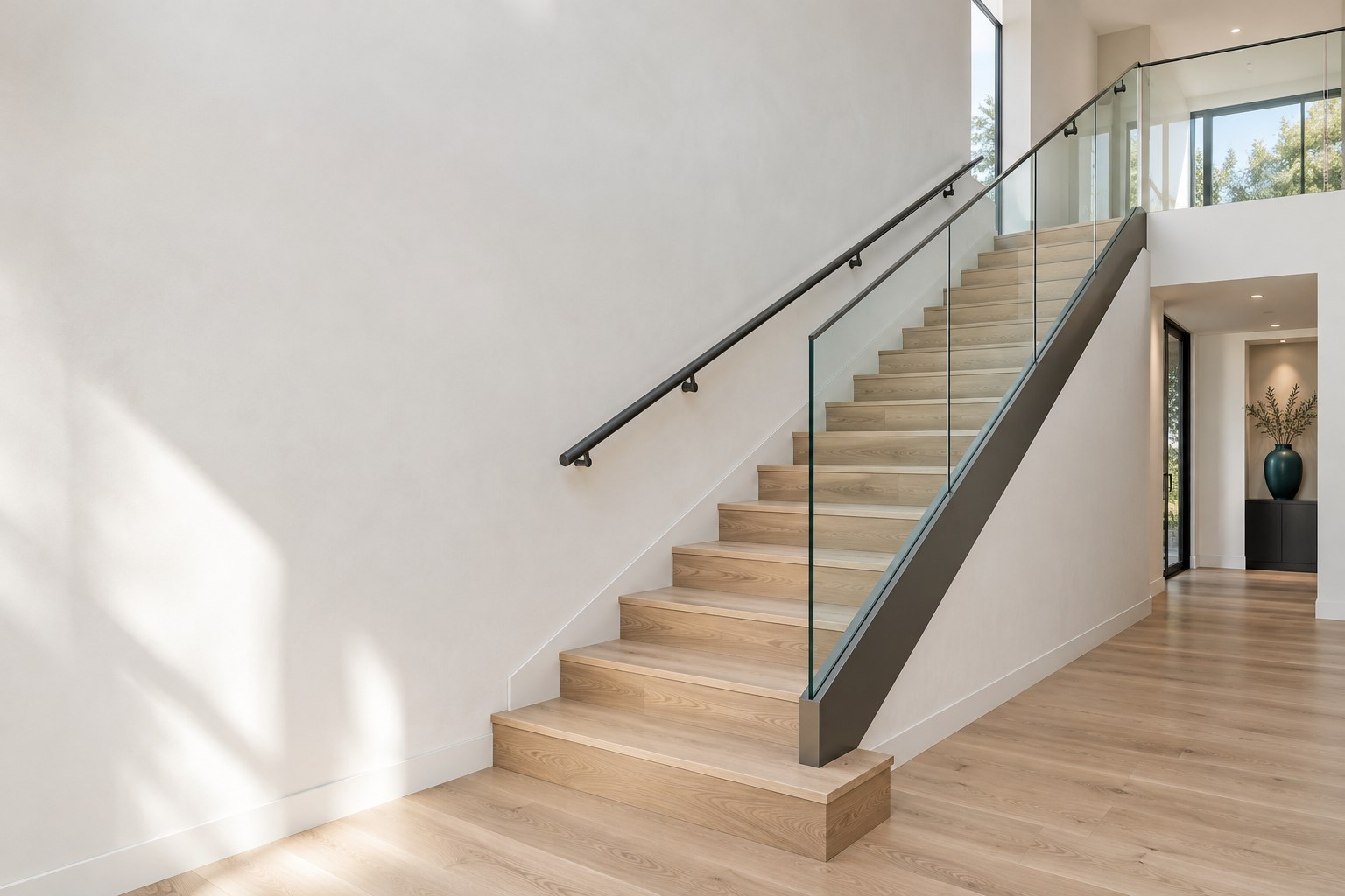 Illustrative interior stair with glass railing and handrail; not a certified construction design.